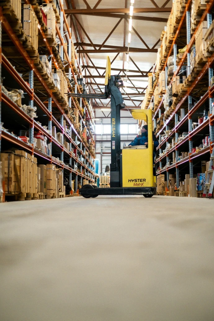 A yellow forklift in a large warehouse